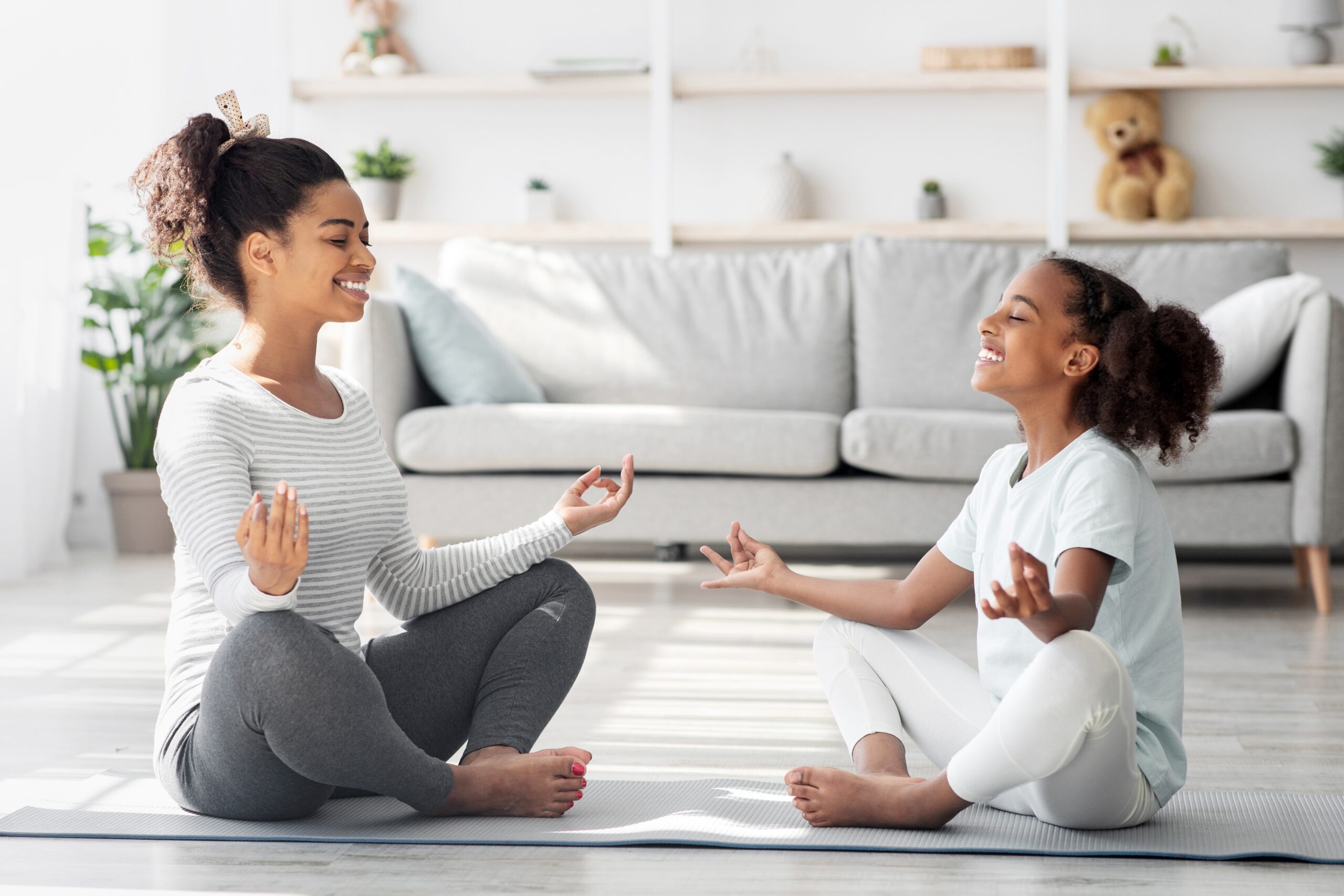 Mom and young girl practicing yoga